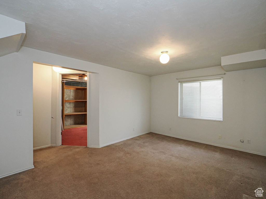 Spare room featuring carpet and baseboards