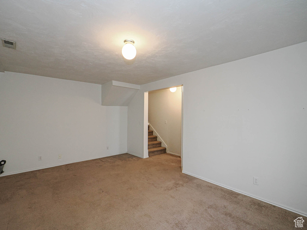 Finished below grade area with carpet floors and stairway
