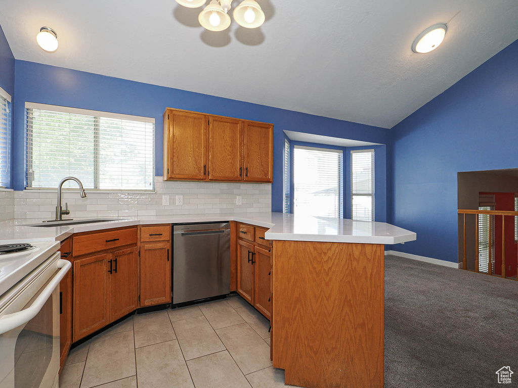 Kitchen with stainless steel dishwasher, a peninsula, a ceiling fan, a sink, and decorative backsplash