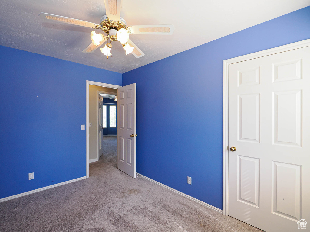 Unfurnished bedroom with carpet flooring, baseboards, and a ceiling fan
