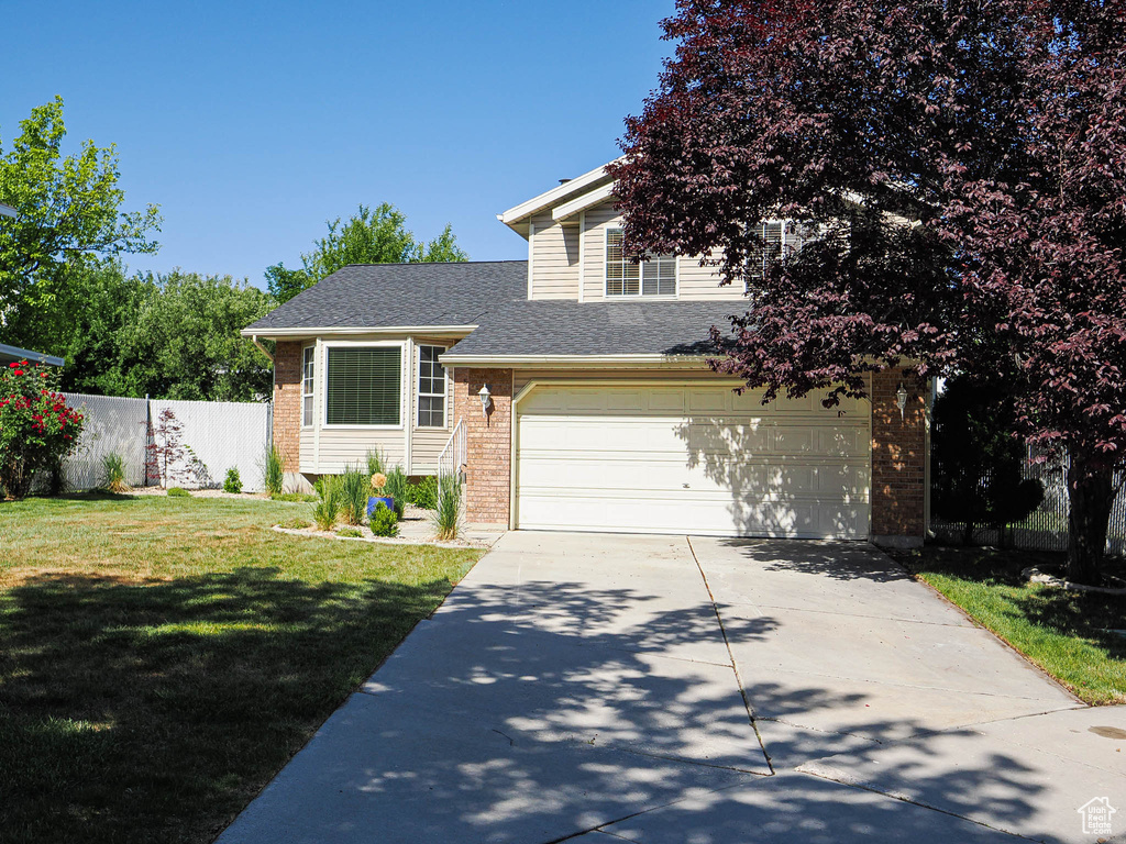View of front of property featuring brick siding, driveway, a garage, and a shingled roof