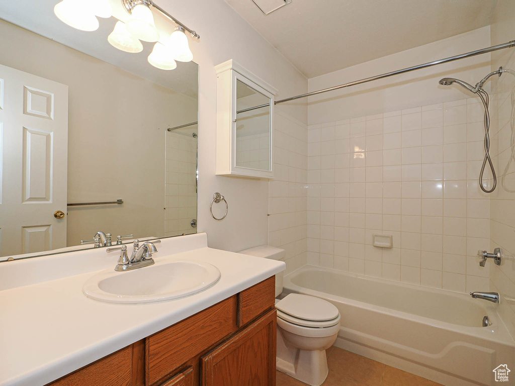 Bathroom with shower / washtub combination, toilet, vanity, and tile patterned flooring