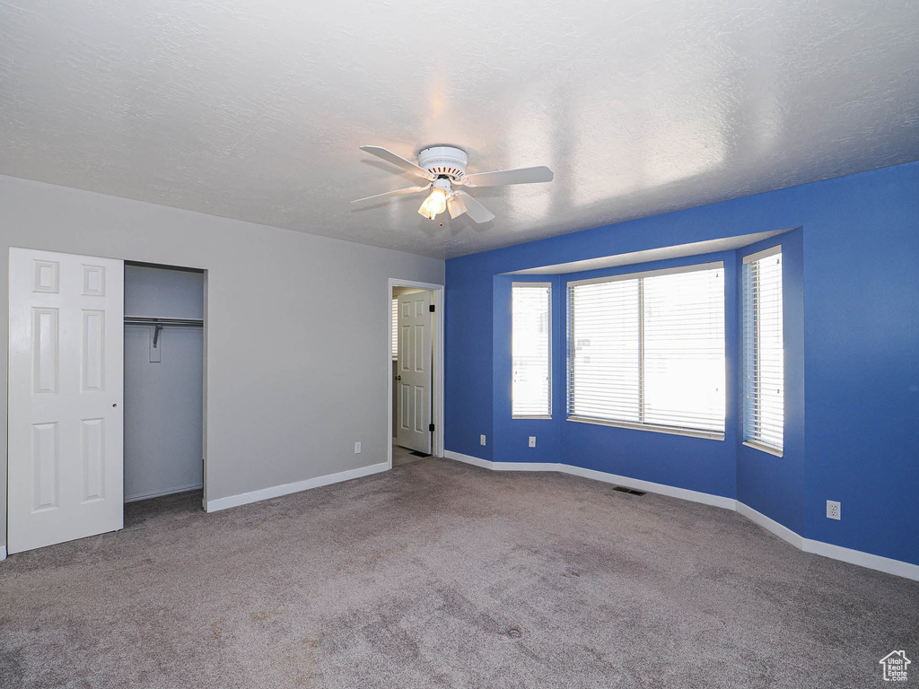 Unfurnished bedroom featuring carpet flooring, multiple windows, and baseboards