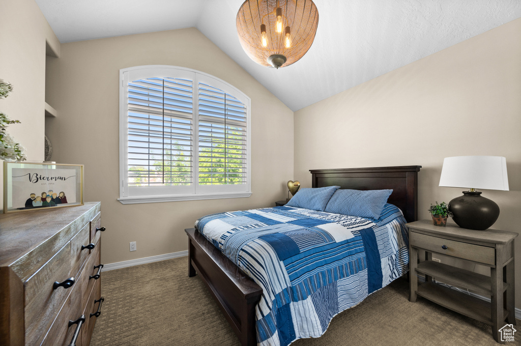 Bedroom with carpet floors, vaulted ceiling, and baseboards