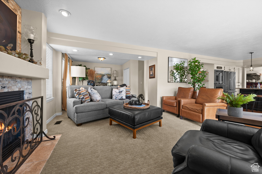 Living room with light colored carpet, a tile fireplace, and recessed lighting