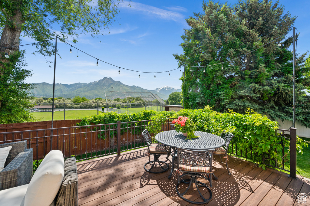 Wooden deck featuring a mountain view and outdoor dining space