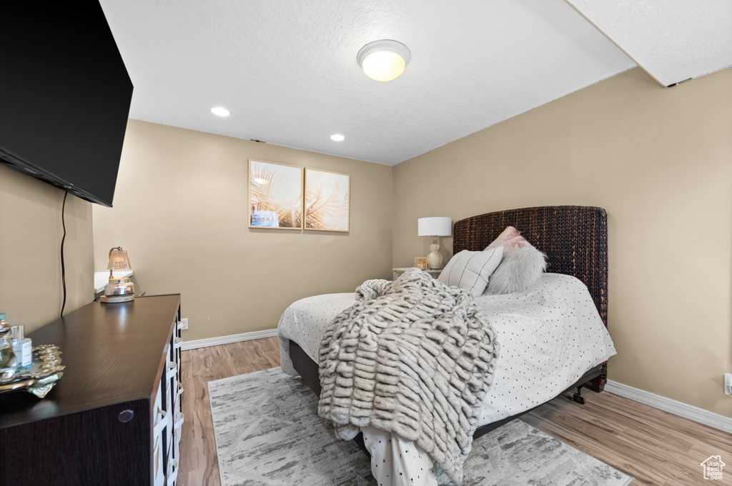 Bedroom featuring baseboards, light wood-style flooring, and recessed lighting