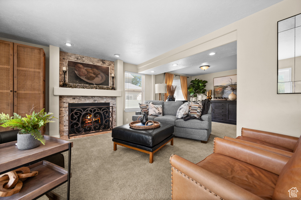 Carpeted living area featuring a large fireplace and recessed lighting