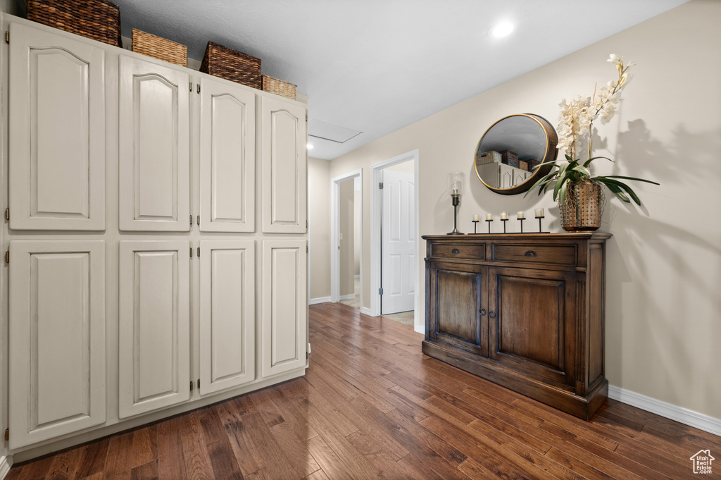 Hall with baseboards, dark wood-type flooring, and recessed lighting