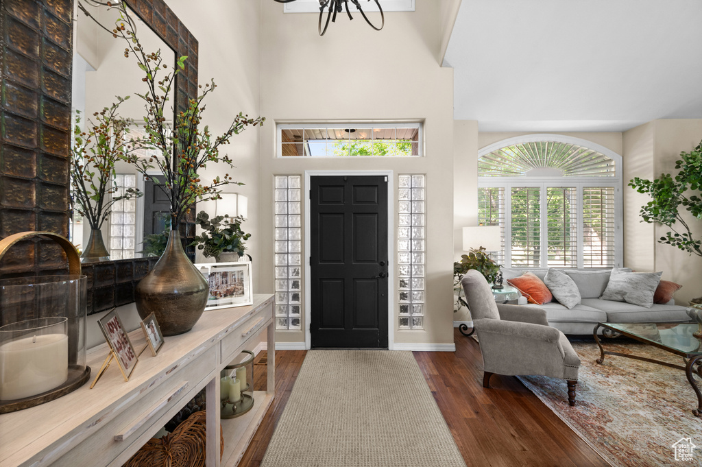 Entrance foyer featuring wood finished floors, a chandelier, and baseboards