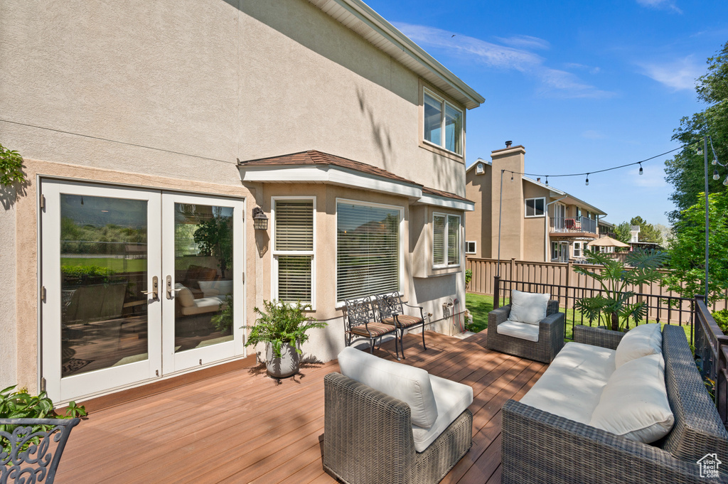 Wooden terrace featuring french doors and an outdoor living space