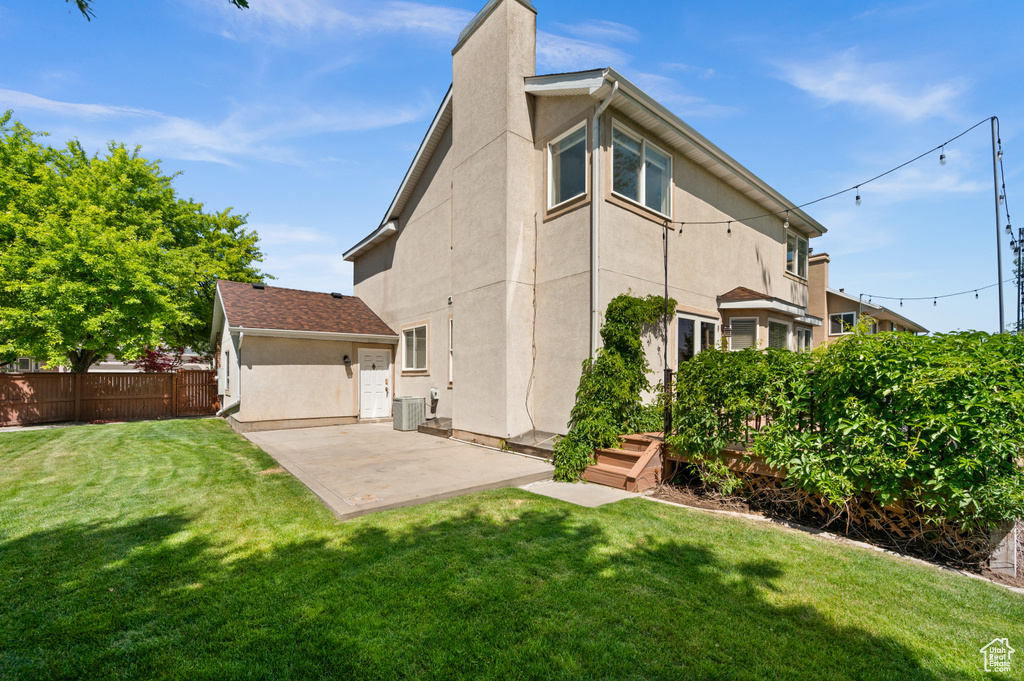 Rear view of property featuring stucco siding, a patio area, a chimney, and cooling unit