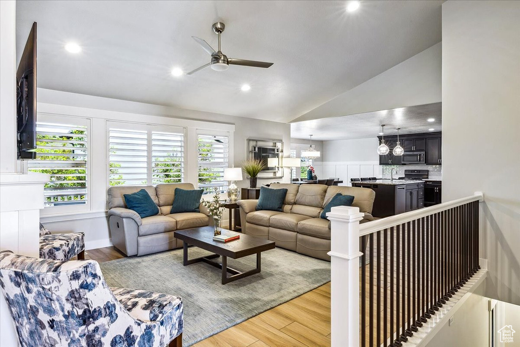 Living room featuring a ceiling fan, light wood-type flooring, lofted ceiling, and recessed lighting