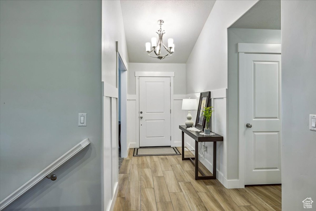 Entryway with a chandelier, light wood-style floors, and baseboards