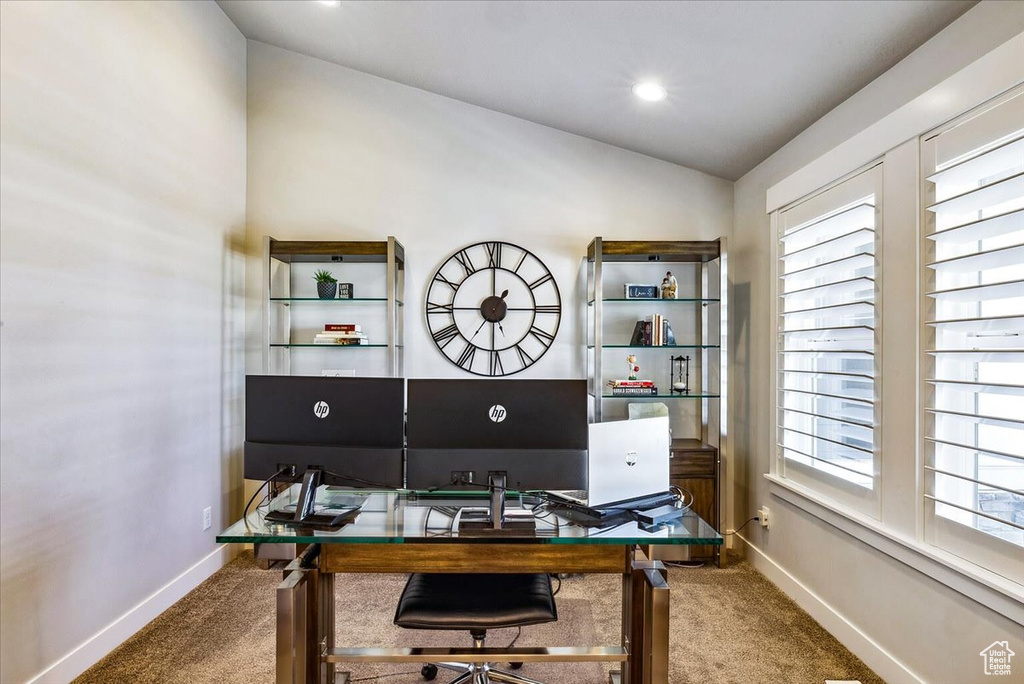 Carpeted office with vaulted ceiling and baseboards