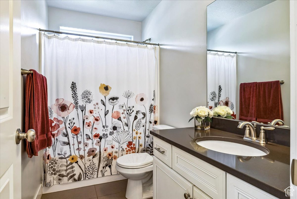 Bathroom featuring vanity, toilet, and tile patterned flooring