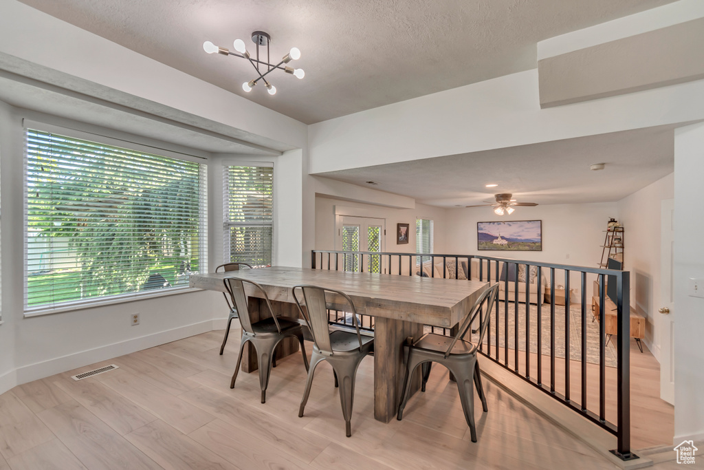 Dining room with baseboards, a chandelier, light wood-style floors, and ceiling fan
