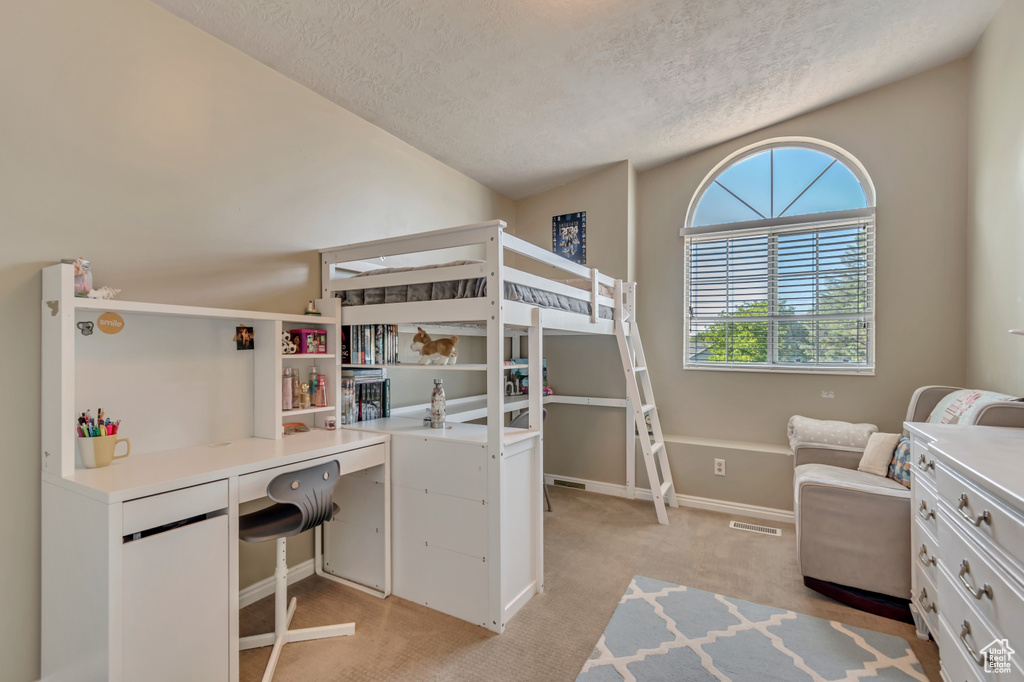 Bedroom with light carpet, a textured ceiling, an office area, and baseboards