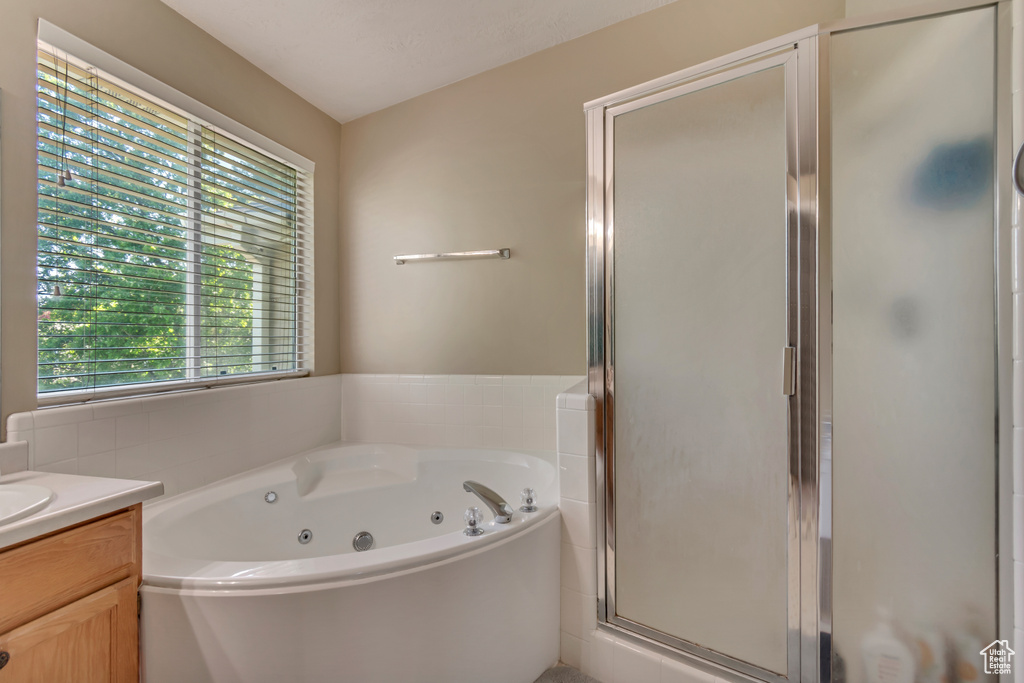 Bathroom with vanity, a whirlpool tub, and a shower stall