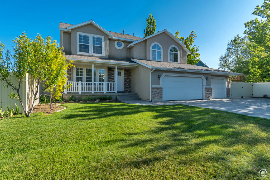 Traditional-style home featuring stucco siding, a porch, stone siding, driveway, and a shingled roof