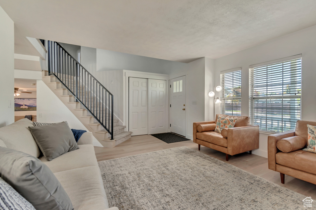 Living area featuring wood finished floors, stairway, and baseboards
