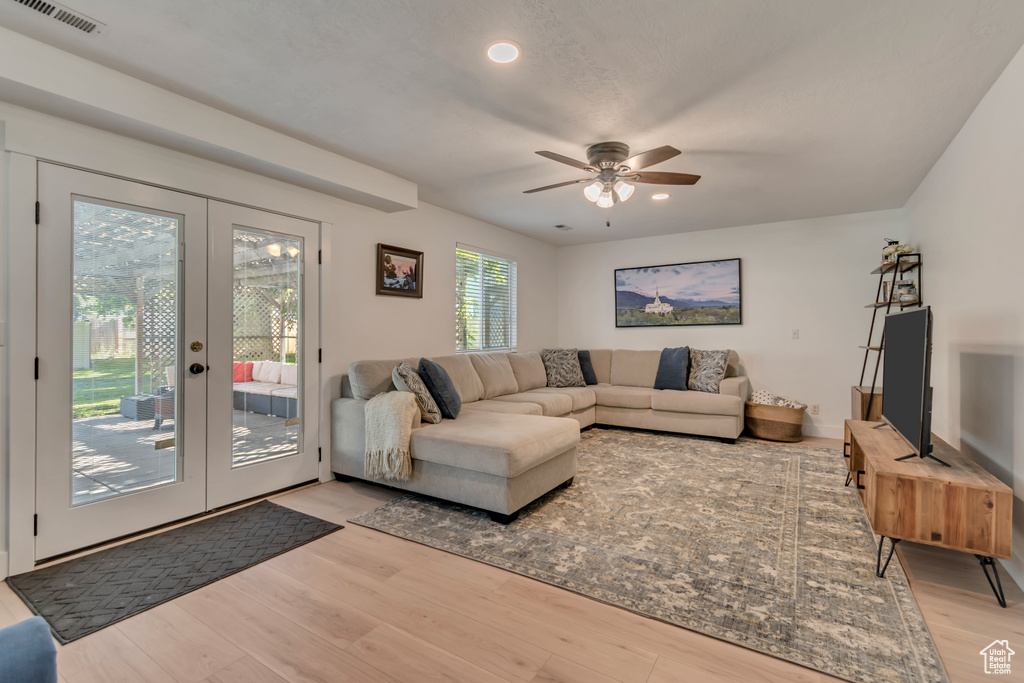Living area featuring light wood-style flooring, a ceiling fan, french doors, and recessed lighting