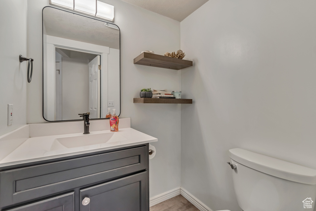 Bathroom featuring toilet, vanity, and baseboards