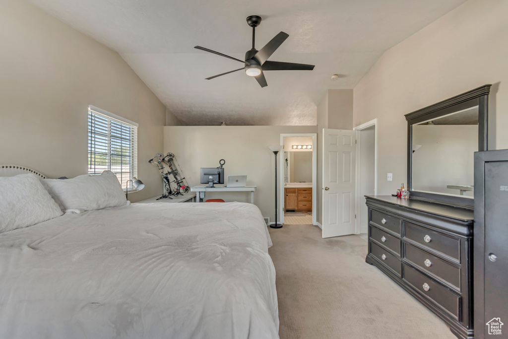 Bedroom featuring lofted ceiling, light colored carpet, connected bathroom, and a ceiling fan
