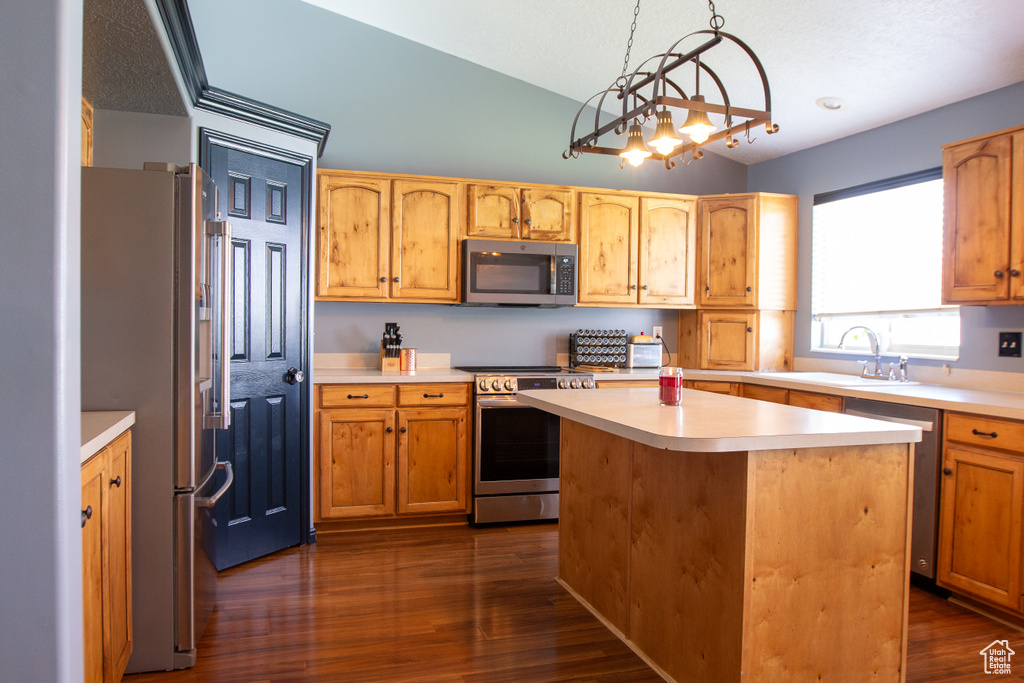 Kitchen with stainless steel appliances, a sink, lofted ceiling, light countertops, and dark wood-style flooring