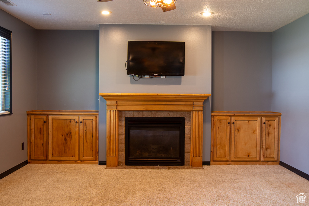 Detailed view of carpet, a tiled fireplace, baseboards, and recessed lighting