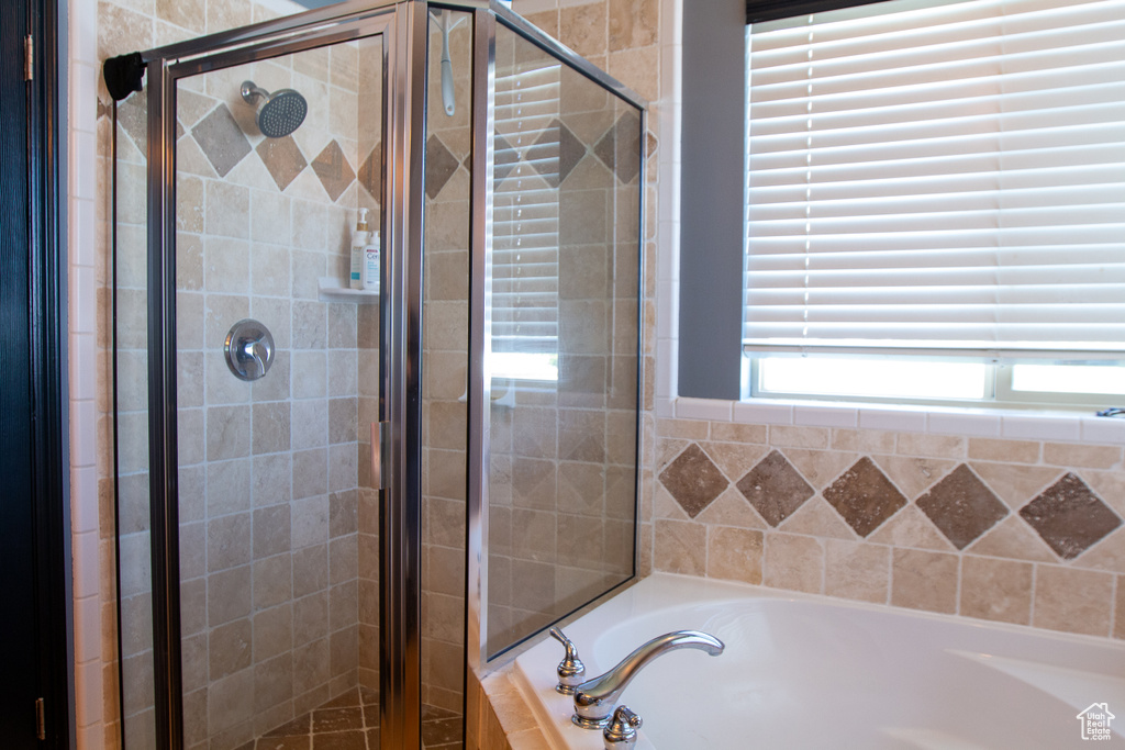 Bathroom featuring a bath and a shower stall