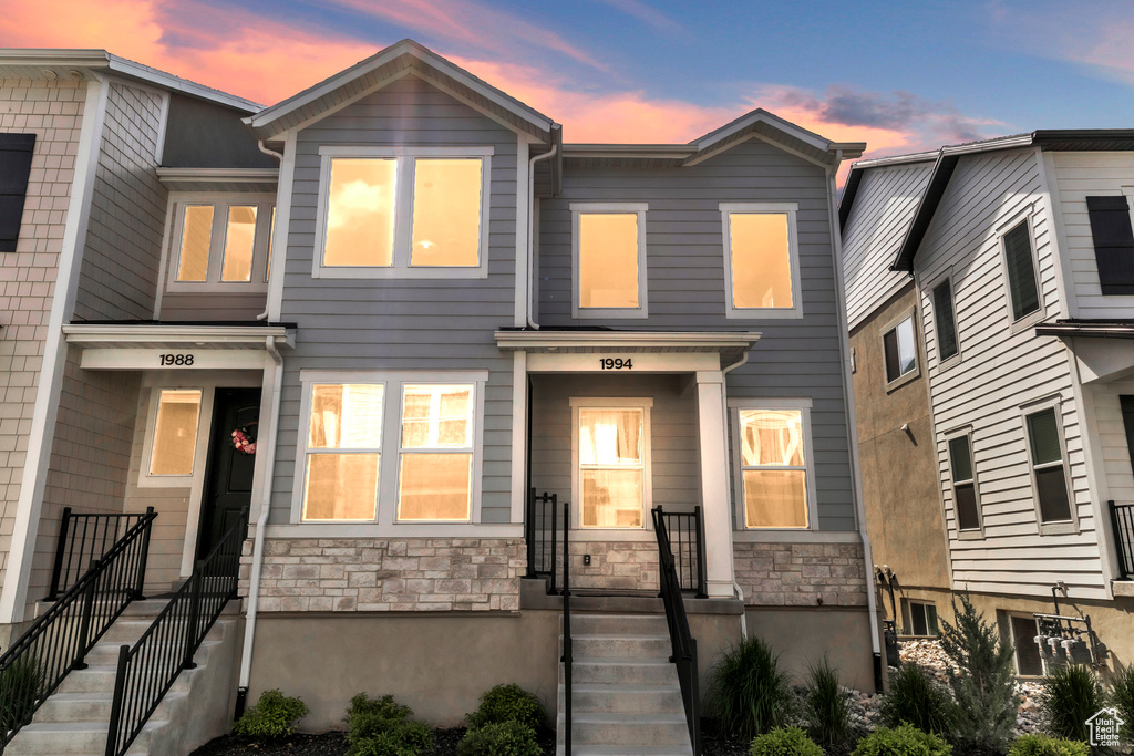 Townhome / multi-family property featuring stone siding