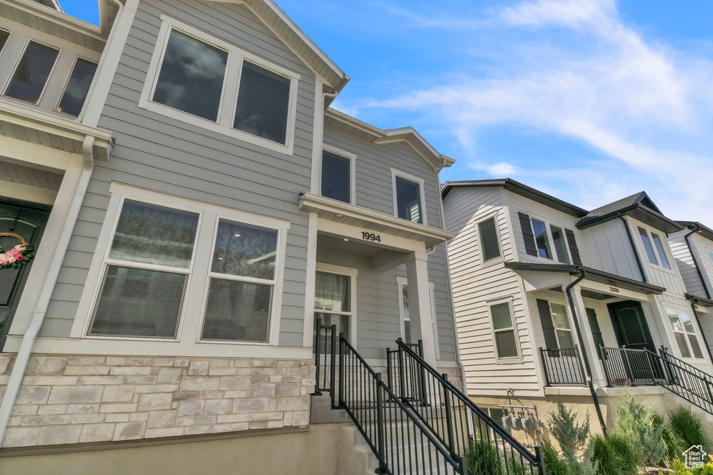 Townhome / multi-family property featuring stone siding