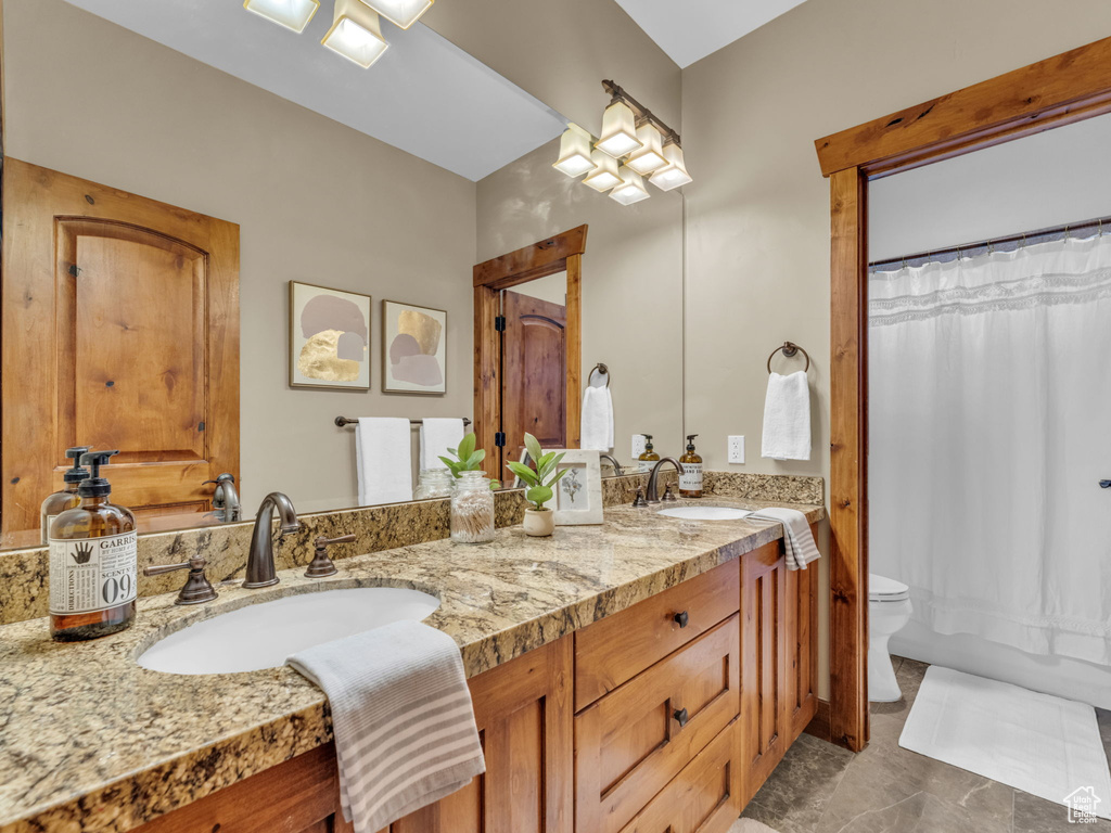 Full bath featuring double vanity and toilet