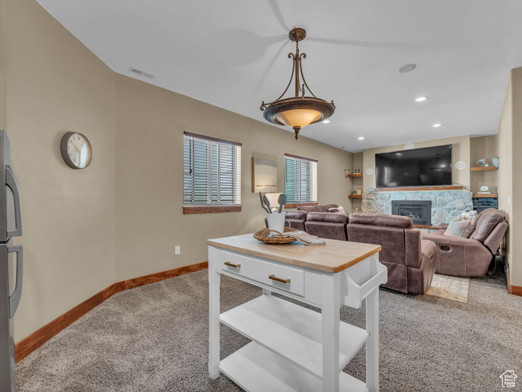 Living room with light colored carpet, baseboards, a fireplace, and recessed lighting