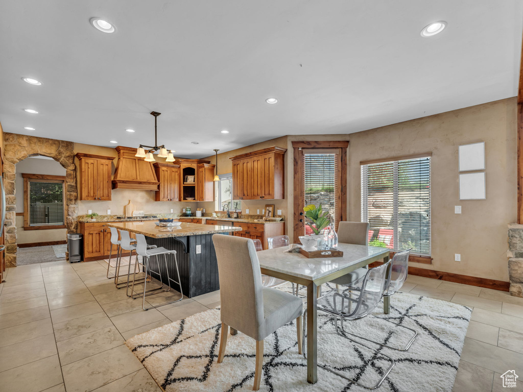 Dining room featuring recessed lighting, light tile patterned flooring, baseboards, and a chandelier