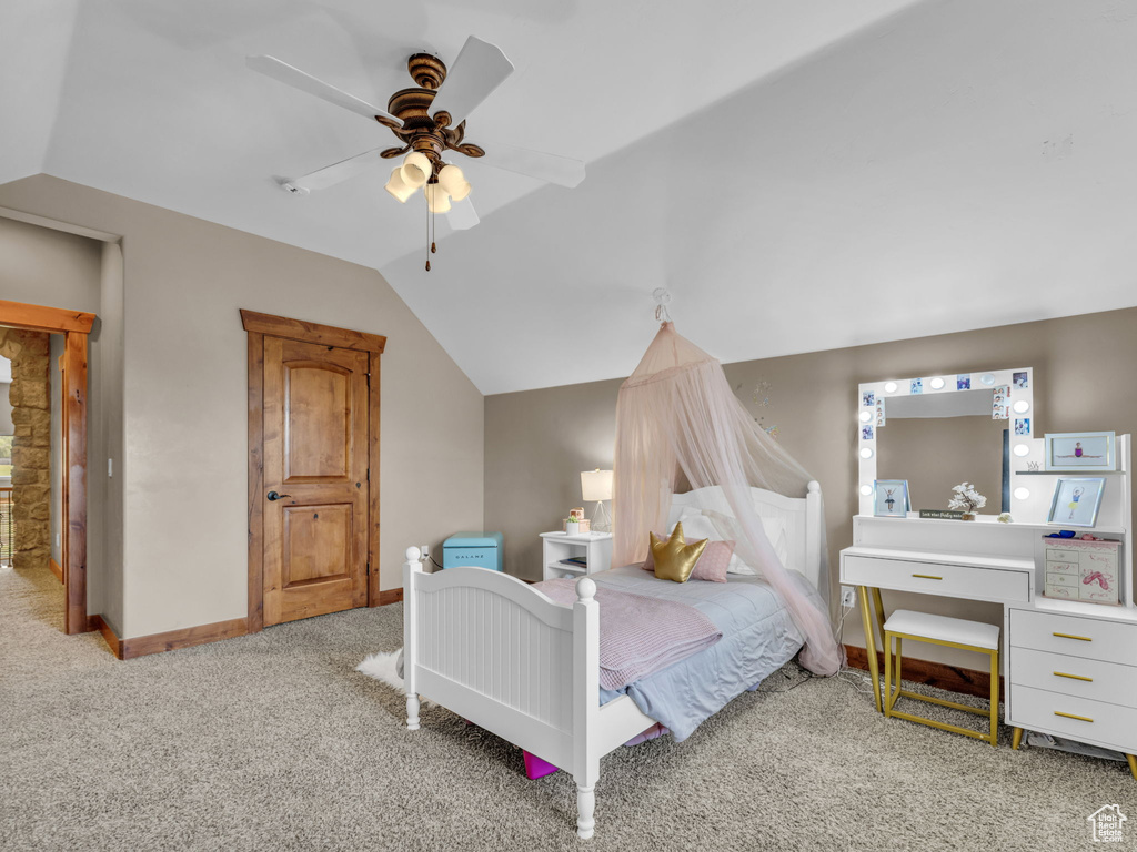 Carpeted bedroom with lofted ceiling, baseboards, and ceiling fan