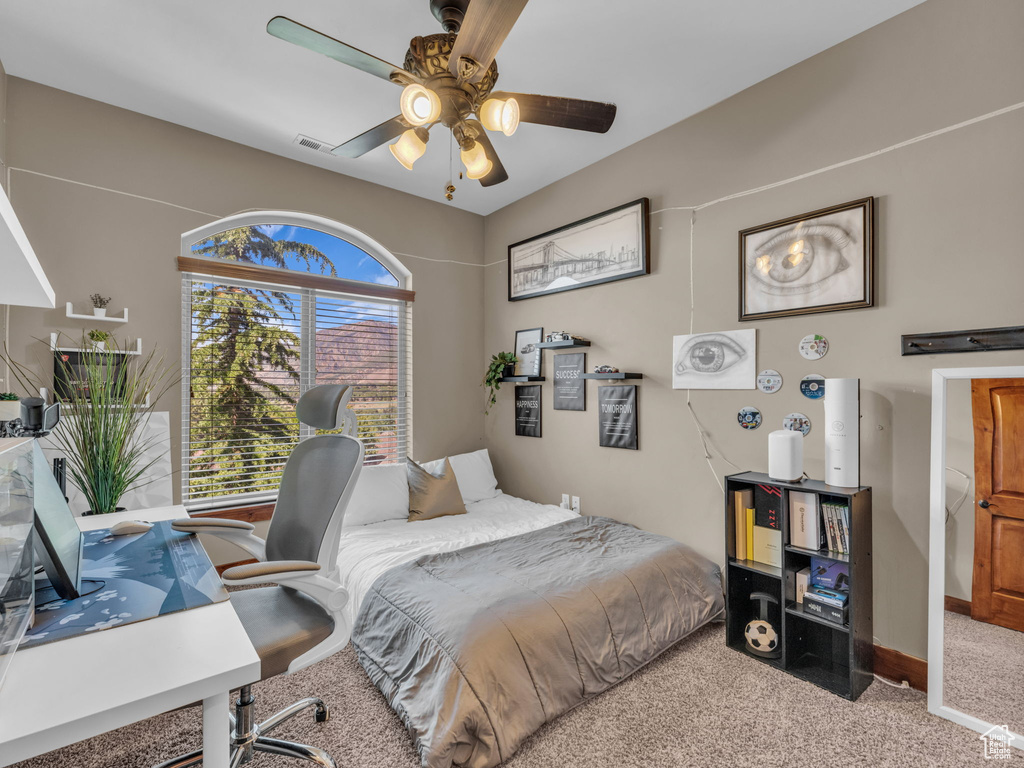 Bedroom with carpet, a desk, baseboards, and ceiling fan