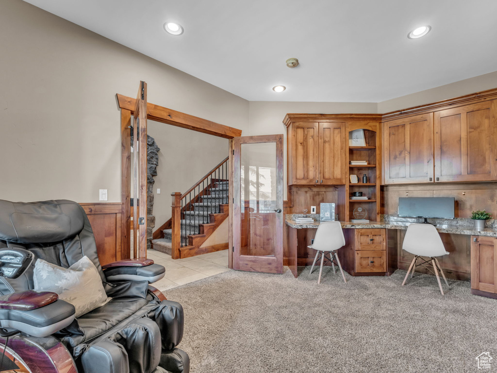 Office space with built in desk, recessed lighting, and light colored carpet
