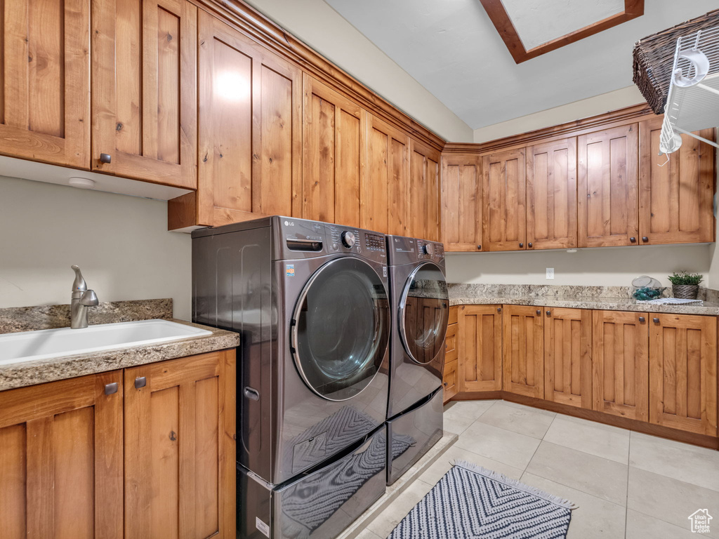Laundry room featuring cabinet space, separate washer and dryer, and light tile patterned floors