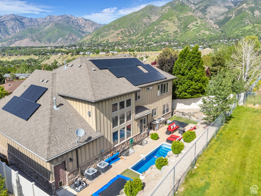 View of subject property featuring a pool area and a mountain backdrop