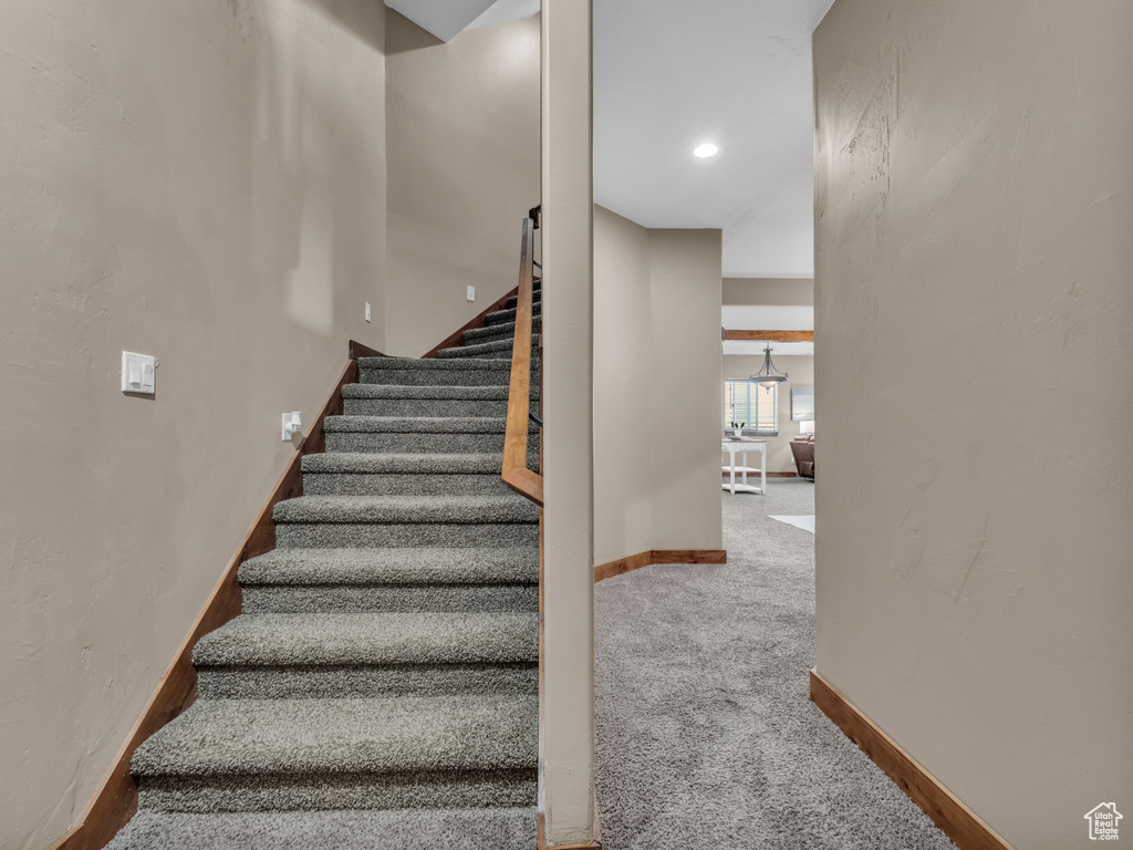 Stairway with baseboards and carpet floors