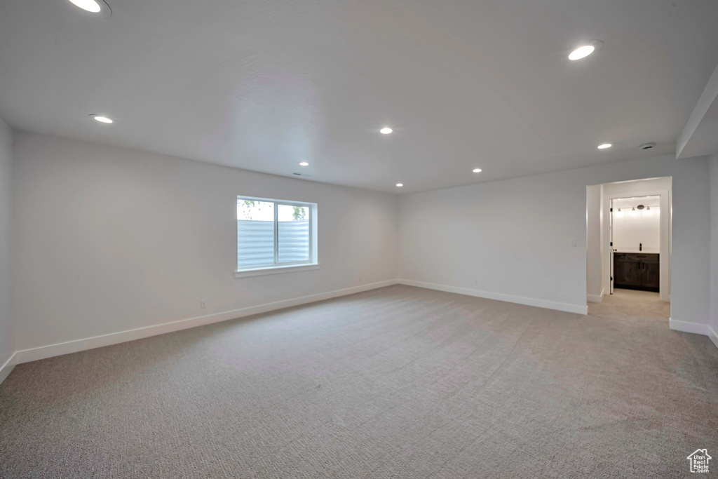 Spare room featuring light colored carpet, baseboards, and recessed lighting
