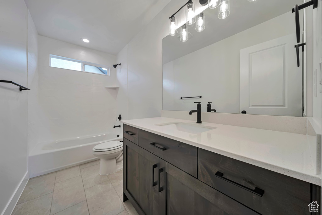 Bathroom with vanity, toilet, bathtub / shower combination, tile patterned floors, and baseboards