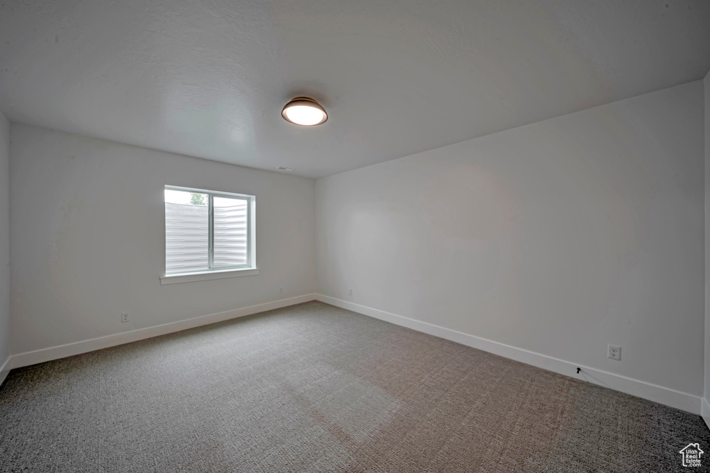 Spare room featuring carpet and baseboards