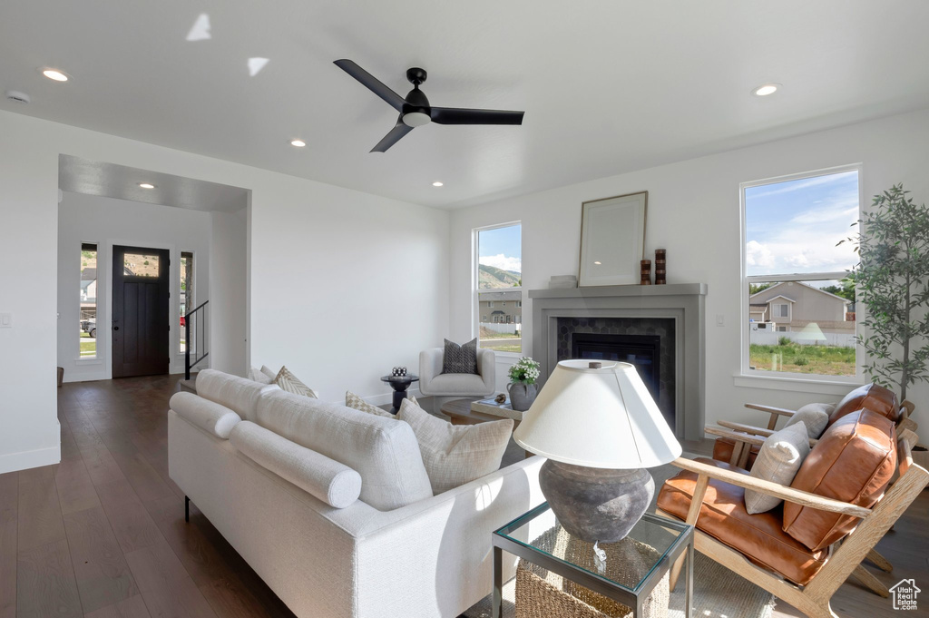 Living room with recessed lighting, a ceiling fan, dark wood-style flooring, and a high end fireplace