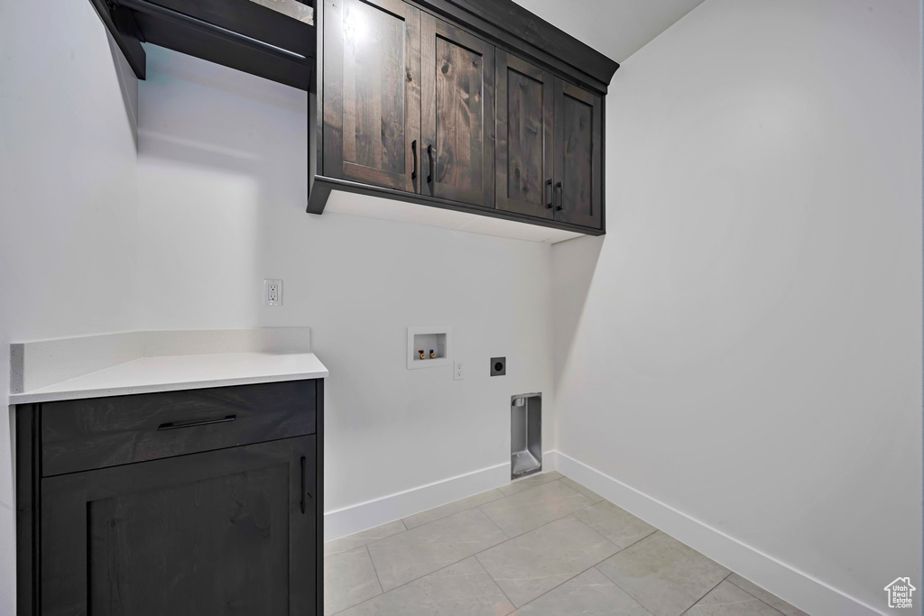Laundry room with cabinet space, washer hookup, electric dryer hookup, and baseboards