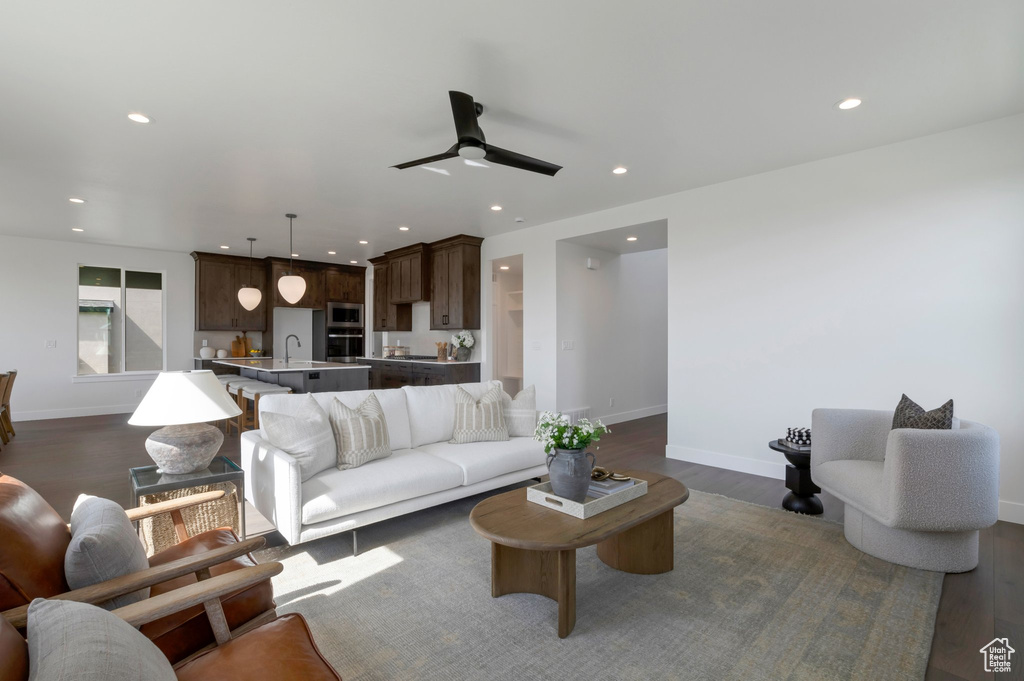 Living room with dark wood finished floors, ceiling fan, and recessed lighting
