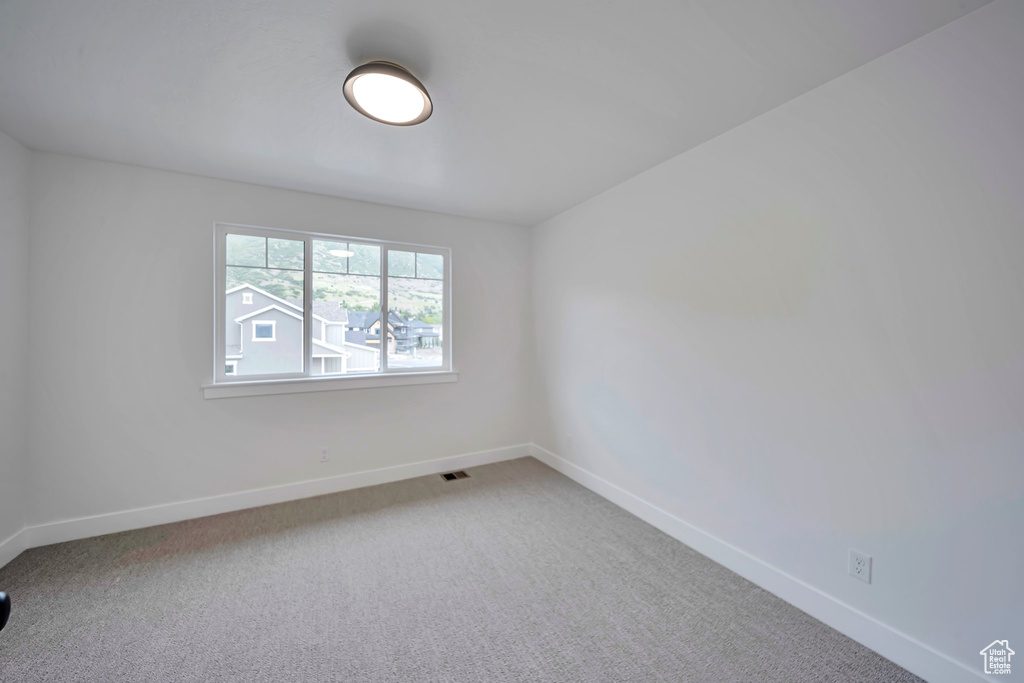 Unfurnished room featuring baseboards and carpet