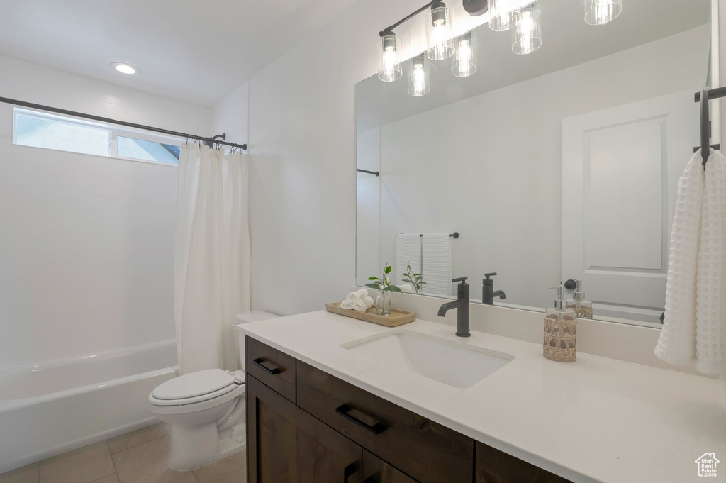 Full bathroom with vanity, shower / tub combo with curtain, and tile patterned floors